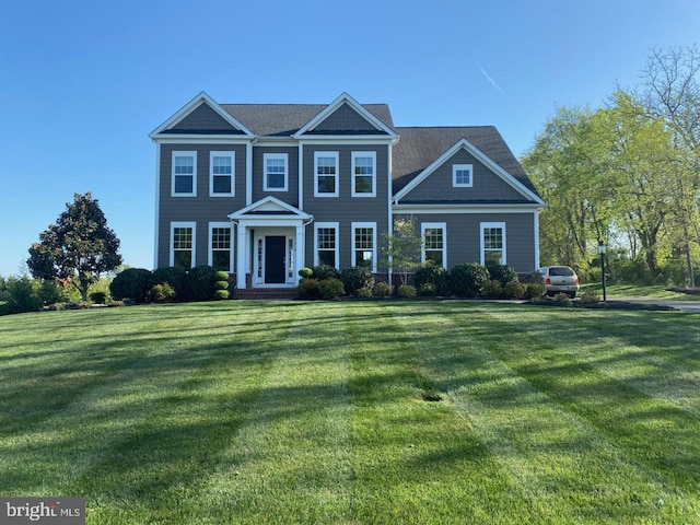 colonial inspired home with a front lawn