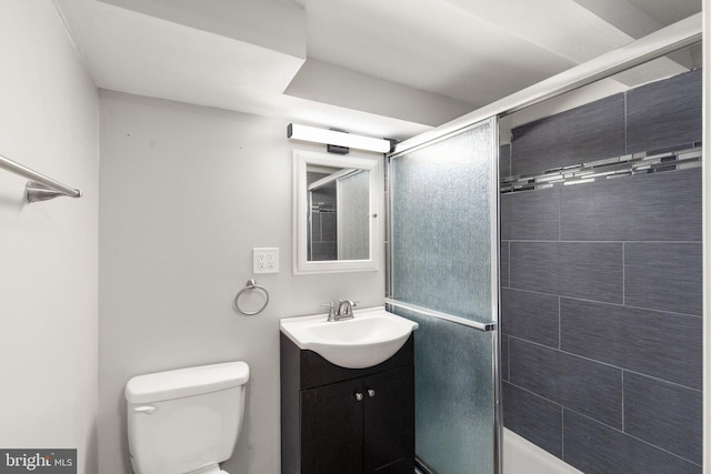 full bath featuring toilet, vanity, and a stall shower