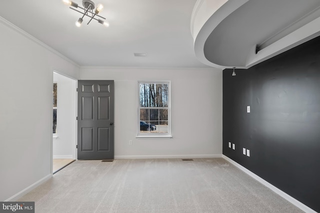 empty room featuring light colored carpet, baseboards, and ornamental molding