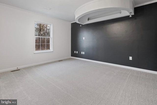 unfurnished room with visible vents, baseboards, carpet, and ornamental molding