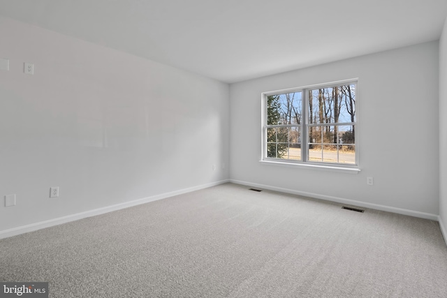 empty room featuring visible vents, baseboards, and carpet floors