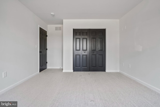 unfurnished bedroom with visible vents, carpet floors, and baseboards