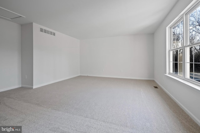 empty room with visible vents, baseboards, and carpet