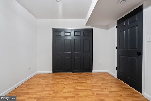 foyer entrance with light wood finished floors and baseboards