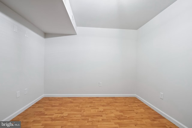 unfurnished room with baseboards and light wood finished floors