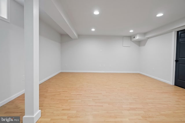 finished below grade area with recessed lighting, baseboards, and light wood-style floors