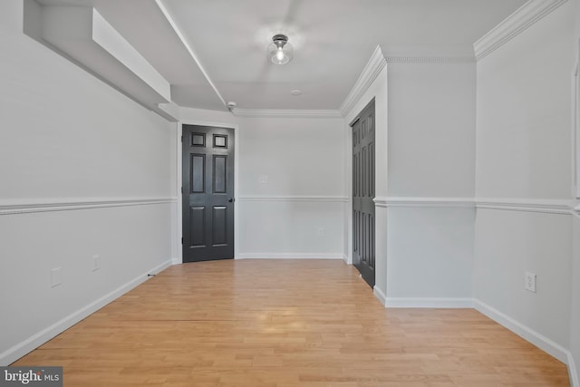 interior space with light wood-style flooring, baseboards, and ornamental molding