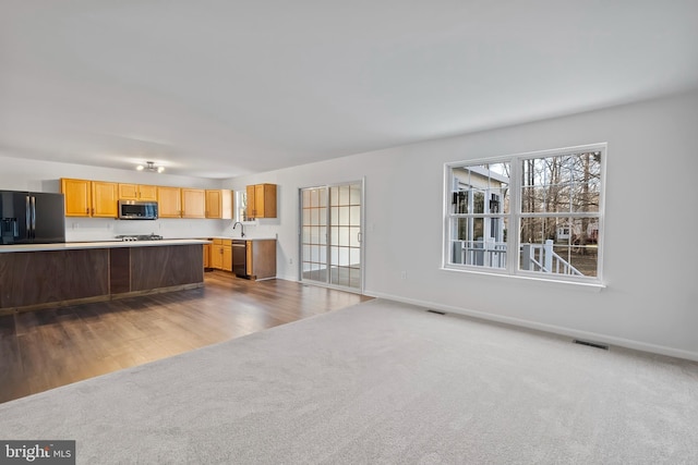 kitchen featuring visible vents, black appliances, carpet flooring, and light countertops