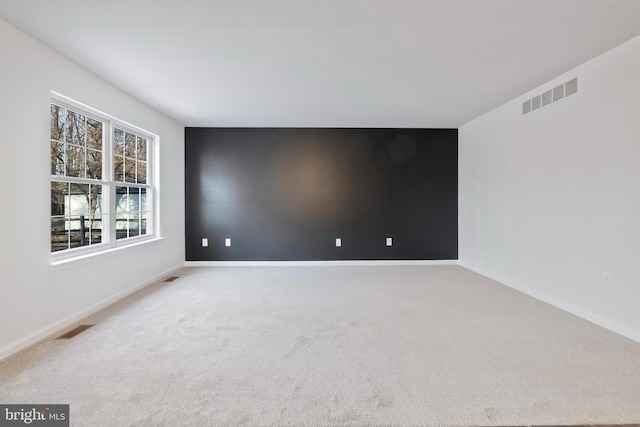 unfurnished room with visible vents, carpet, and baseboards