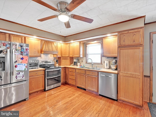 kitchen featuring light wood finished floors, premium range hood, light countertops, stainless steel appliances, and a sink