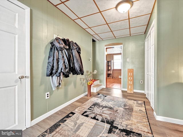 corridor with baseboards and wood finished floors