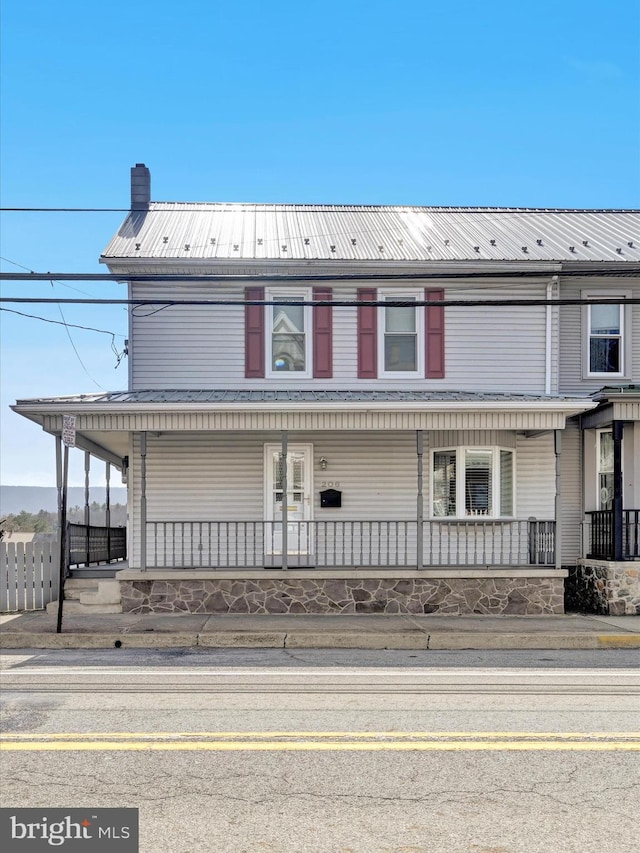 view of property with a porch and a chimney