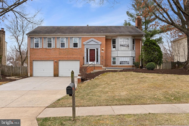 split foyer home featuring brick siding, concrete driveway, a chimney, and fence