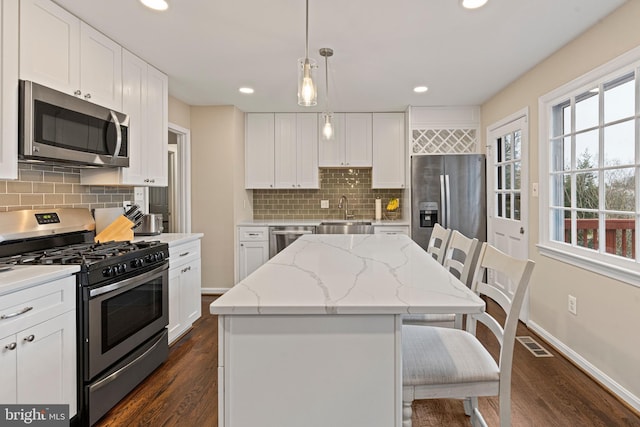 kitchen featuring white cabinetry, visible vents, appliances with stainless steel finishes, and a center island