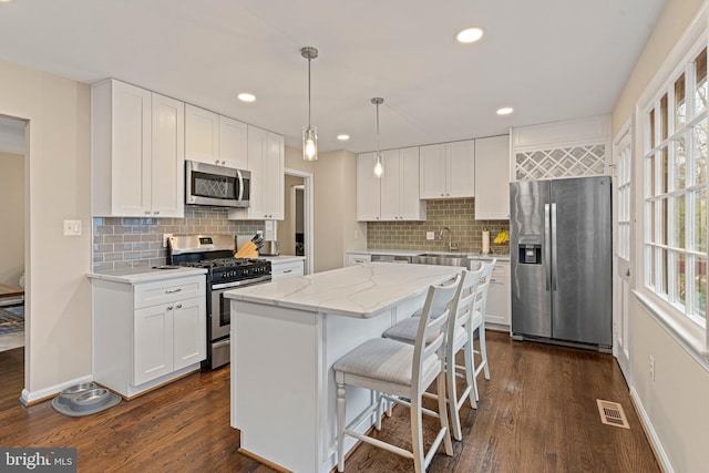 kitchen with a healthy amount of sunlight, visible vents, dark wood-style flooring, and stainless steel appliances