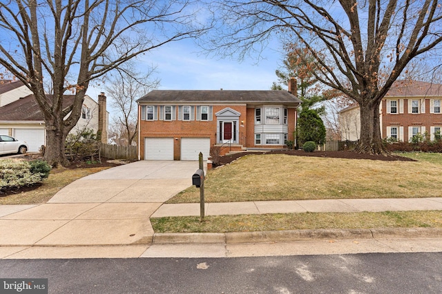 raised ranch with a front lawn, driveway, fence, an attached garage, and brick siding