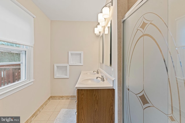 bathroom featuring tile patterned floors, double vanity, baseboards, and a sink