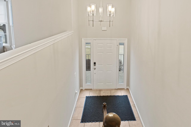 entryway featuring baseboards, a notable chandelier, and light tile patterned flooring