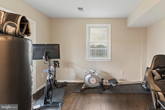 workout room with wood finished floors, visible vents, and baseboards