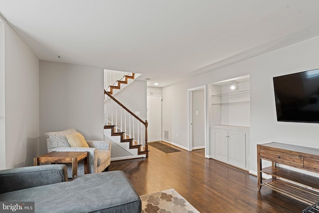 living area with recessed lighting, baseboards, wood finished floors, and stairs