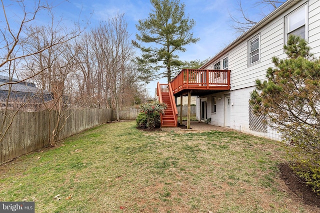 view of yard featuring a deck, stairs, and a fenced backyard