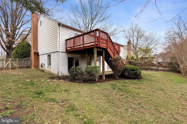 rear view of house featuring stairs, a lawn, a chimney, a deck, and a fenced backyard