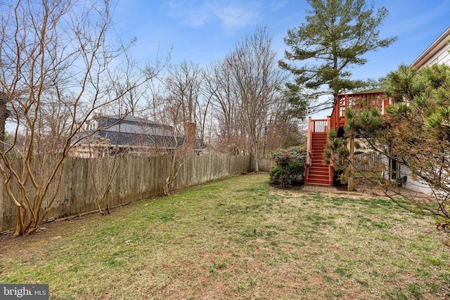 view of yard with a deck, stairs, and a fenced backyard