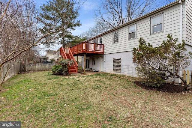 rear view of property featuring stairway, a deck, a lawn, and a fenced backyard