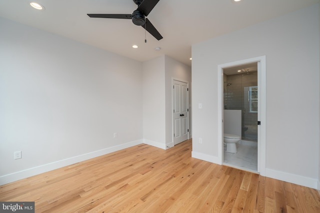 unfurnished bedroom featuring baseboards, recessed lighting, wood finished floors, ensuite bath, and a ceiling fan