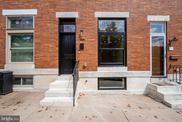 entrance to property featuring brick siding