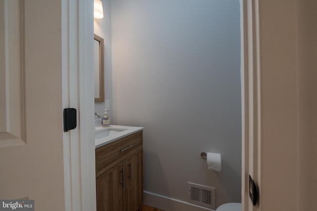 half bathroom with visible vents, toilet, and vanity