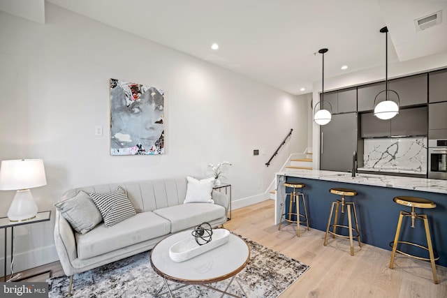 living area featuring light wood finished floors, visible vents, recessed lighting, and baseboards