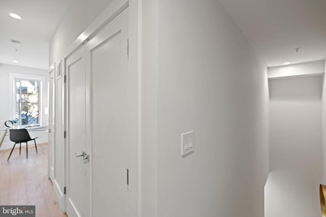 hallway featuring recessed lighting, baseboards, and light wood-style flooring