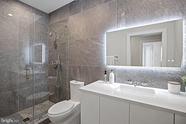 full bathroom with backsplash, toilet, vanity, a stall shower, and tile walls