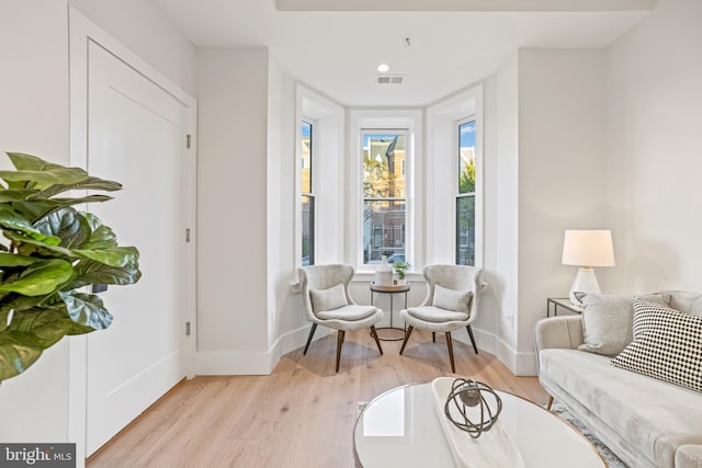 sitting room with visible vents, baseboards, and light wood-style flooring