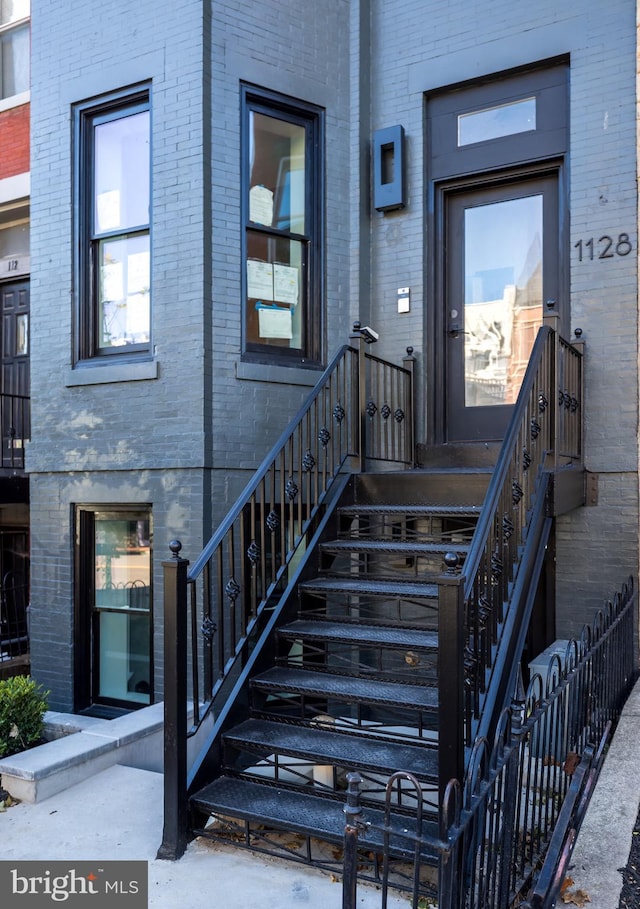 entrance to property featuring brick siding