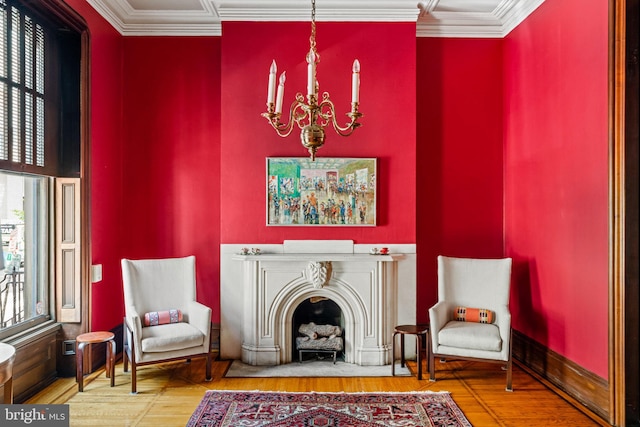 living area featuring a notable chandelier, a healthy amount of sunlight, wood finished floors, and crown molding