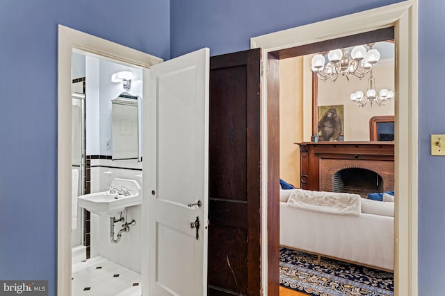 ensuite bathroom featuring a sink, ensuite bathroom, and a chandelier