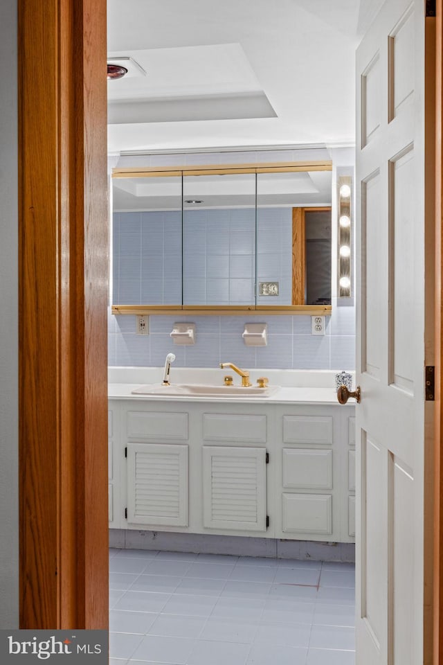 bathroom featuring tile patterned flooring, backsplash, and vanity