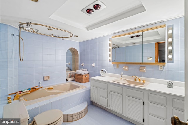 full bath featuring tile patterned floors, a raised ceiling, tile walls, and vanity