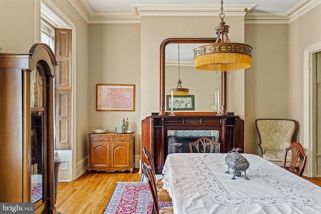 dining room with crown molding, wood finished floors, and baseboards