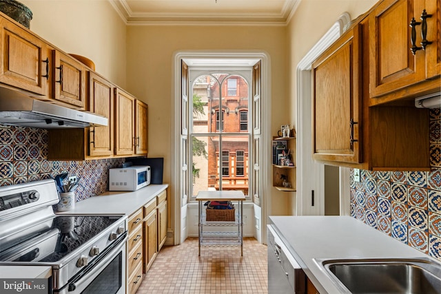 kitchen with ornamental molding, decorative backsplash, light countertops, stainless steel appliances, and under cabinet range hood