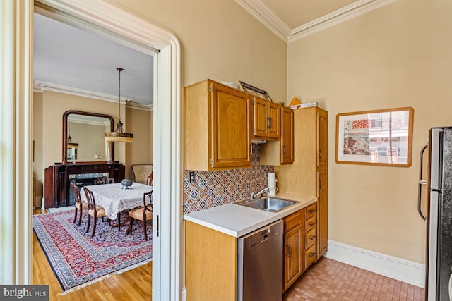 kitchen with dishwasher, ornamental molding, decorative backsplash, freestanding refrigerator, and a sink