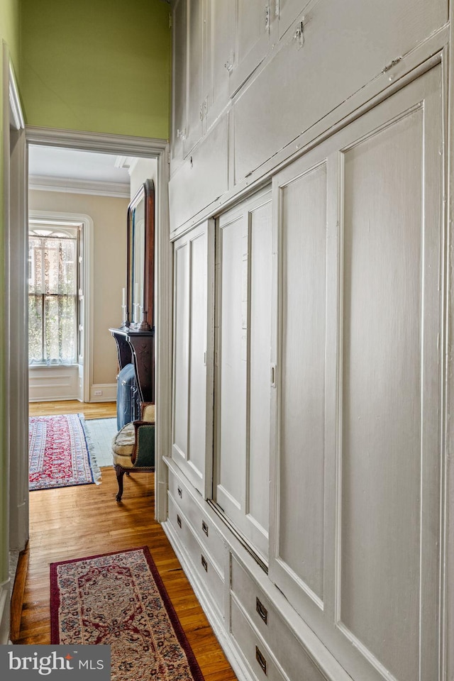 mudroom with wood finished floors and ornamental molding