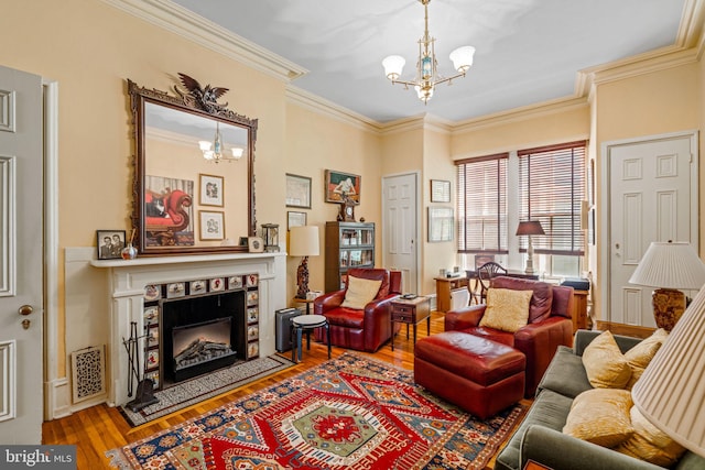 living room featuring visible vents, crown molding, a chandelier, a tile fireplace, and wood finished floors