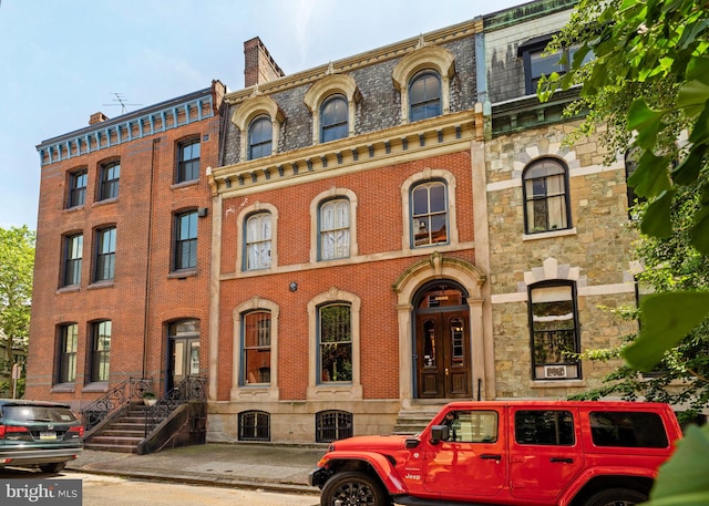 view of front facade featuring brick siding and mansard roof