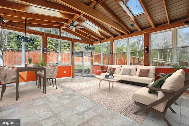 sunroom with a wealth of natural light, vaulted ceiling with skylight, and ceiling fan