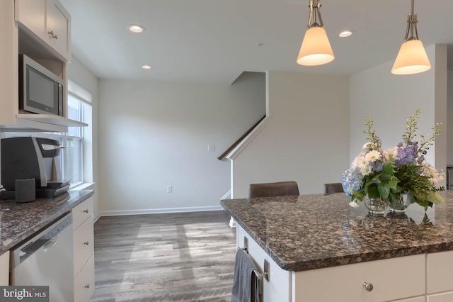 kitchen featuring wood finished floors, recessed lighting, pendant lighting, dishwasher, and stainless steel microwave