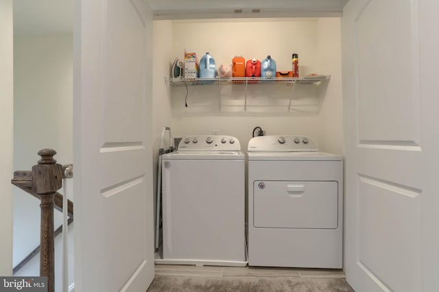 clothes washing area featuring laundry area and washer and clothes dryer