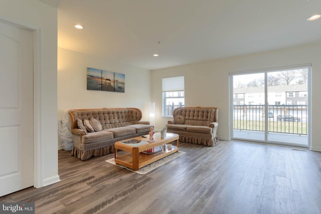 living room featuring recessed lighting, baseboards, and wood finished floors